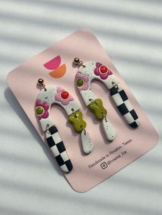 two giraffe shaped hair clips on top of a piece of pink paper with black and white stripes