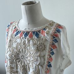 Nwt Beautiful Johnny Was Embroidered Cap Sleeve Top. Ivory (Jw Color States “Natural”) Background With Multi Colored Embroidered Florals And Geometric Designs. Please See Close Up Pictures For All The Fabulous Details With Metallic And Soft Playful Colors. This Top Has Small Pockets In The Front (Also Pictured Close Up) And A Raw Edge Cool Neck Detail. Easy To Dress Up Or Down!! This Is A Forever Classic Piece With Its Incredible Detailing!! Summer Festival Floral Embroidered Fabric, Embroidered Cream Top For Festival, Embroidered Cream Tops For Festival, White Bohemian Tops With Geometric Embroidery, White Bohemian Embroidered Top For Summer, Bohemian Floral Embroidered Fabric For Summer, White Short Sleeve Tops With Tonal Embroidery, Cream Embroidered Tops For Vacation, White Embroidered Top For Vacation