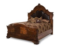 a wooden bed with ornate carvings on the headboard and foot board, along with decorative pillows