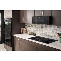 a kitchen with stainless steel appliances and white counter tops, including a microwave oven above the stove