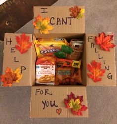 an open box filled with snacks and autumn leaves on the floor next to a sign that says i can't help for you