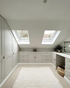 an attic bedroom with skylights and white cabinets on the walls, carpeted flooring