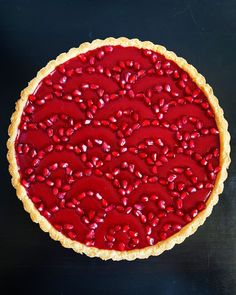 a pie with pomegranates on it sitting on top of a table