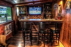 a home bar with stools and a television