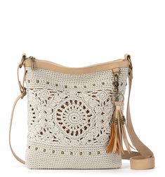 a white crocheted purse with tassels on the front and shoulder strap