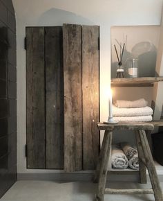 a bathroom with a wooden cabinet next to a towel rack and towels on the floor