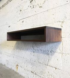 a wooden shelf mounted to the side of a building