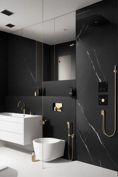 a black and white bathroom with gold fixtures on the wall, marble countertops and floor