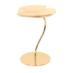 a gold table with a circular base and a leaf design on the top, in front of a white background