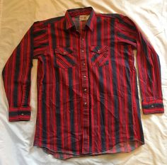 "Vintage 1970s 1980s 2XLT Saddle King Tall Western Striped Shirt  Cowboy look on this shirt  XXL tall as well for a large man  Heavy Weight 100 percent cotton  18.5\" neck Sleeve 38 inch long sleeve button up  Collared neck  Gentle Wear  Excellent used condition  Vintage tags intact  Red and Demin striped material super heavy duty  This shirt will last for years to come  Made in USA Wash cold  warm dryer  iron or steam for pressing  All Vintage clothing is sold AS-IS  Fast shipping" 1970s Style Long Sleeve Cotton Shirt, 1970s Long Sleeve Cotton Shirt, Etiquette Vintage, Tommy Hilfiger Long Sleeve, Festival Shirts, Retro Tee, Large Man, Twill Shirt, Cow Boy