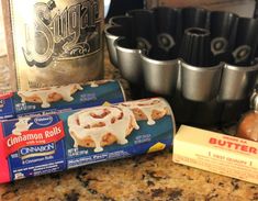 the ingredients for cinnamon rolls are sitting on the counter next to baking pans and an egg carton