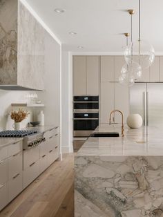 a large kitchen with marble counter tops and stainless steel appliances