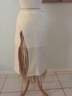 a mannequin dressed in white and brown with fringes on it's legs