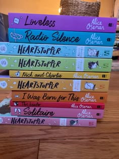 a stack of children's books sitting on top of a wooden table next to a wicker basket