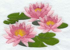 three pink flowers with green leaves in the snow on a white surface, embroidered onto a piece of fabric