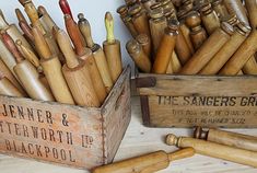 two wooden boxes filled with lots of different types of pens and pencils next to each other