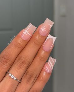 These medium square nails showcase a matte nude base adorned with subtle sparkle details and white snowflake accents. Each nail has a unique design, from gift-wrapped art to soft stripes, adding a fun, winter vibe. Perfect for a playful yet refined winter manicure. Pretty Christmas Nails Square, Christmas Nails Overlay, Winter Xmas Nails, Short Simple Christmas Nails Acrylic, Small Acrylic Nails Christmas, Winter Nails Square Medium, Christmas Short French Tip Nails, Festive Nails Square, Christmas Nails Square Short Simple