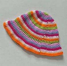 a multicolored crocheted hat laying on top of a table