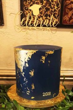 a blue and gold birthday cake sitting on top of a table