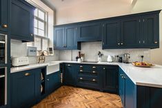 a kitchen with blue cabinets and wooden floors