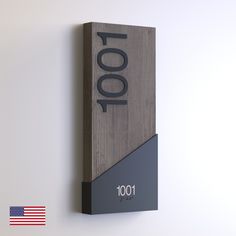 a wooden plaque with the word 100 on it and an american flag in the background