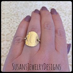 a woman's hand with a gold ring on it that has the letter d in it