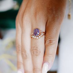 a woman's hand with a ring on it and an amethyst stone