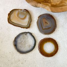 four different types of agate stones on a counter top next to a wooden bowl