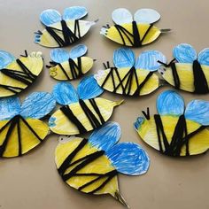 paper plate crafts with blue and yellow butterflies on top of each other, all made out of construction paper