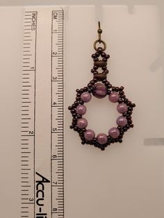 a beaded necklace is shown next to a measuring ruler