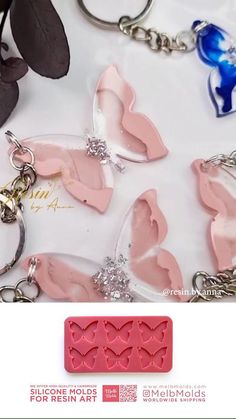 the butterfly key chain is pink and has four hearts on it, as well as two smaller