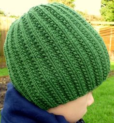 a young boy wearing a green knitted hat