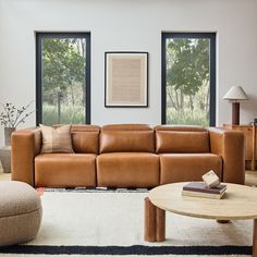 a living room filled with furniture and large windows