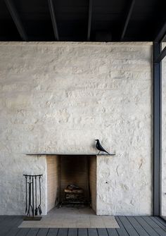 a black bird sitting on top of a fireplace