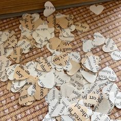 several pieces of paper that have been cut into hearts with words written on them and placed on a table