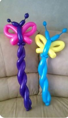 two balloons shaped like butterflies sitting on top of a couch