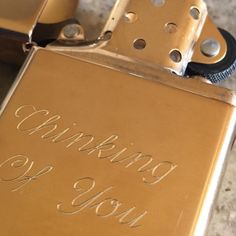 a close up of a lighter with writing on the side and metal parts around it