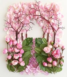 pink flowers and green leaves are arranged in the shape of a circle