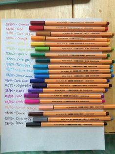 many different colored pencils are lined up on a sheet of paper with words written in it