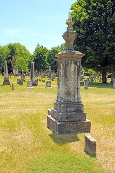 an old cemetery with many headstones in the grass and trees behind it stock photos