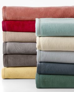 towels stacked on top of each other in different colors and sizes, with one folded over the