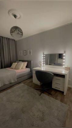 a bedroom with a bed, desk and mirror on the wall next to a window