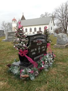 a cemetery with wreaths and christmas trees on the ground in front of a church