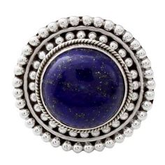 Glistening like a clear sky at dusk a circular gemstone of precious lapis lazuli sits atop a sterling silver crown. Neeru Goel of India presents this sterling silver cocktail ring reminiscent of a royal sunset on a summer evening. Celestial Blue Cabochon Jewelry, Round Lapis Lazuli Cabochon Rings, Blue Celestial Cabochon Jewelry, Celestial Style Blue Cabochon Jewelry, Lapis Lazuli Cabochon Rings, Unique Lapis Lazuli Jewelry, Large Round Sterling Silver Gemstones, Celestial Blue Round Jewelry, Blue Celestial Round Jewelry