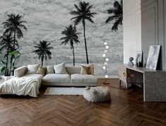 a living room with palm trees on the wall and wood flooring in front of it