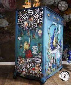 an artisticly painted cabinet in front of a wallpapered background