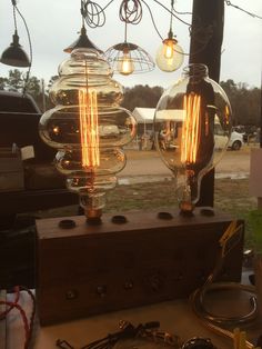 two light bulbs sitting on top of a wooden box next to some wires and other items