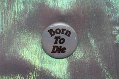 a button with the words born to die on it in brown and green foiling