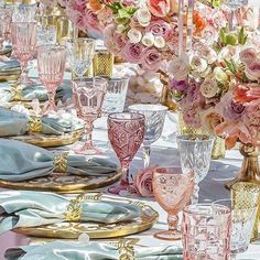 there is a table set with pink and white flowers