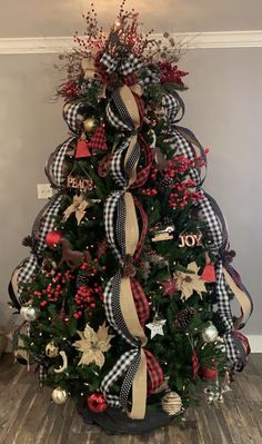 a christmas tree decorated with red, white and black ribbons